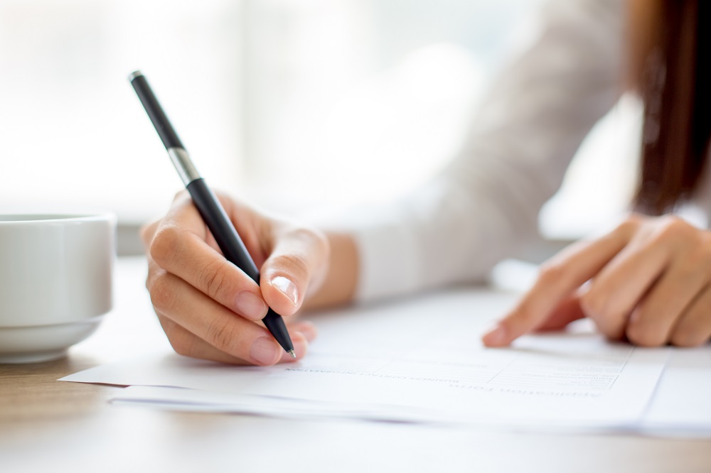 Hand-businesswoman-writing-paper-office