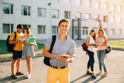 Happy-student-with-note-books-backpack-smiling-while-standing